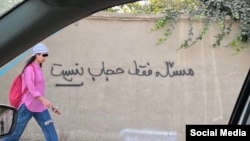  Иранская девушка. Надпись на стене: "Проблема не только в хиджабе" 