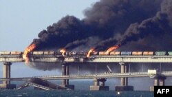 Black smoke billows from a fire on the Kerch bridge that links Crimea to Russia, after a truck exploded, near Kerch, on October 8, 2022.