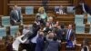 The brawl erupted after an opposition lawmaker threw water on Prime Minister Albin Kurti (right) as he spoke before parliament in Pristina on July 13.