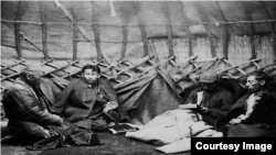 ОГПУ (СССР Эл комиссарлар кеңешине караштуу Бирдиктүү мамлекеттик саясий башкармалык) кызматкерлери басмачылардын тыңчысы делген кишини суракка алып жаткан учур. 1929-жыл. Тарыхчы Гүлзада Абдалиева архивден алган сүрөт. 