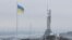 The Ukrainian national flag flies next to the Motherland Monument during the first snowfall of winter in Kyiv on November 22. 
