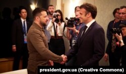 Президент України Володимир Зеленський і президент Франції Емманюель Макрон (праворуч) під час зустрічі в кулуарах саміту «Групи семи». Хіросіма, Японія, 20 травня 2023 року