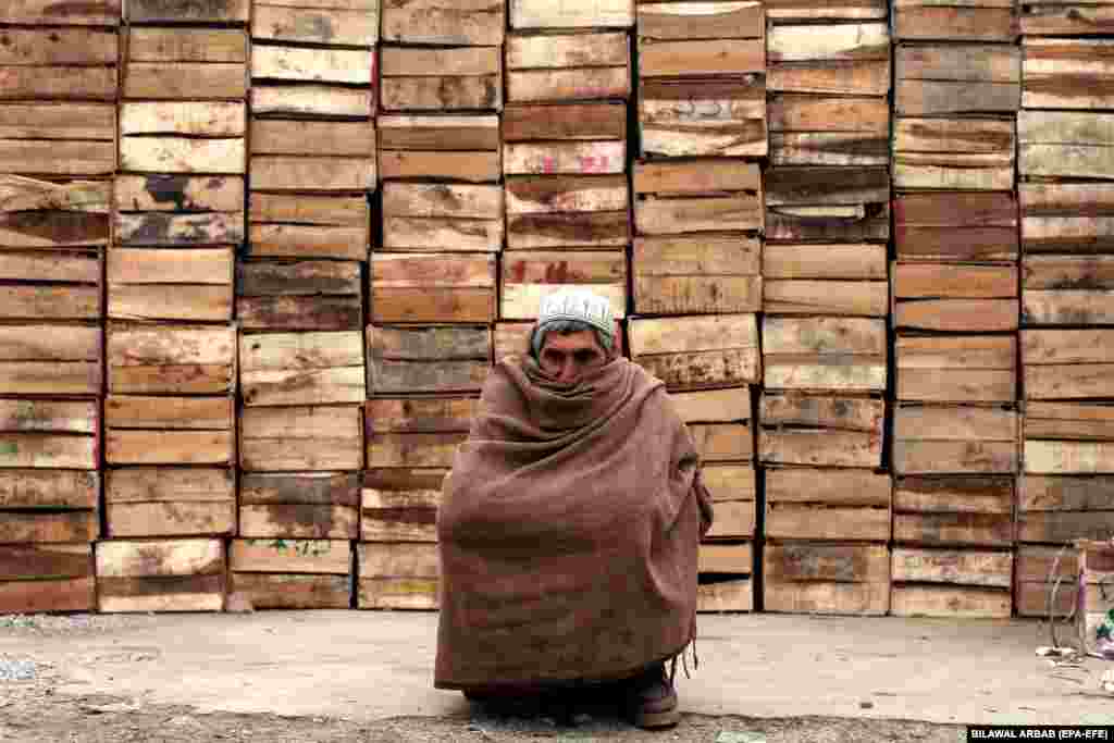 Пакистандын Пешавар шаары. Туман жана суукта көчөдө жоолук жамынып отурган киши.&nbsp;