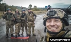 Олександр Шелехань з товаришами, які стоять на прапорі Росії, вересень 2022 року