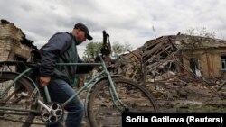 Росія регулярно завдає ударів по Слов'янську. На фото: місцевий житель минає руїни будівель після російської атаки, 11 травня 2023 року