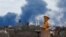 Smoke rises behind a World War II memorial in Donetsk, Russian-controlled Ukraine, on February 19.