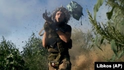 A Ukrainian soldier fires a rocket-propelled grenade launcher toward Russian positions at the front line close to Donetsk on August 19.