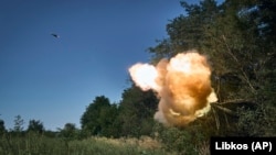 Ukrainian soldiers fire a self-propelled howitzer toward Russian positions at the front line in Donetsk region.