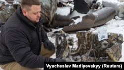 Представник прокуратури показує уламки ракети, яка, на думку правоохоронців, була виготовлена в Північній Кореї і використана під час удару по Харкову 6 січня 2024 року