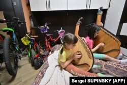 Антоніна і Катерина грають на бандурах в коридорі квартири, де вони ховаються під час російських ударів по Києву