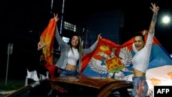 Жени празнуват по улиците на Подгорица, развявайки знамената на Черна гора и Сърбия, след победата на Яков Милатович на президентските избори в неделя, 02 април 2023 г.