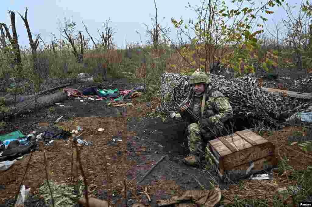 A Ukrainian soldier inspects the former Russian position.