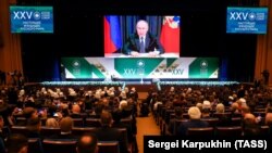 Володимир Путін (на екрані) під час виступу на засіданні XXV Всесвітнього Російського народного собору у Державному Кремлівському палаці, де була огллошена «священная война Западу». Москва, 28 листопада 2023 року