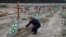 Bucha Deputy Mayor Serhiy Shepetko places flowers on graves of unidentified people killed by Russian soldiers during the occupation of the town outside Kyiv at the town's cemetery in February 2023.