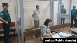 Abduqodir Muminov in the defendant's cage in a Tashkent courtroom in July
