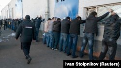 Москванын Бирюлёв районундагы жашылча кампа комплексинде текшерилип жаткан эмгек мигранттары. 14-октябрь, 2013-жыл.