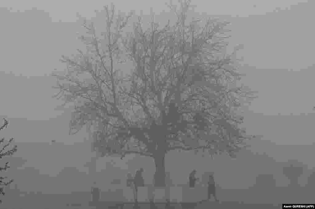 Пакистан, Исламабад. Тумандуу таңда эс алуу багында сейилдеп жүргөндөр.&nbsp;