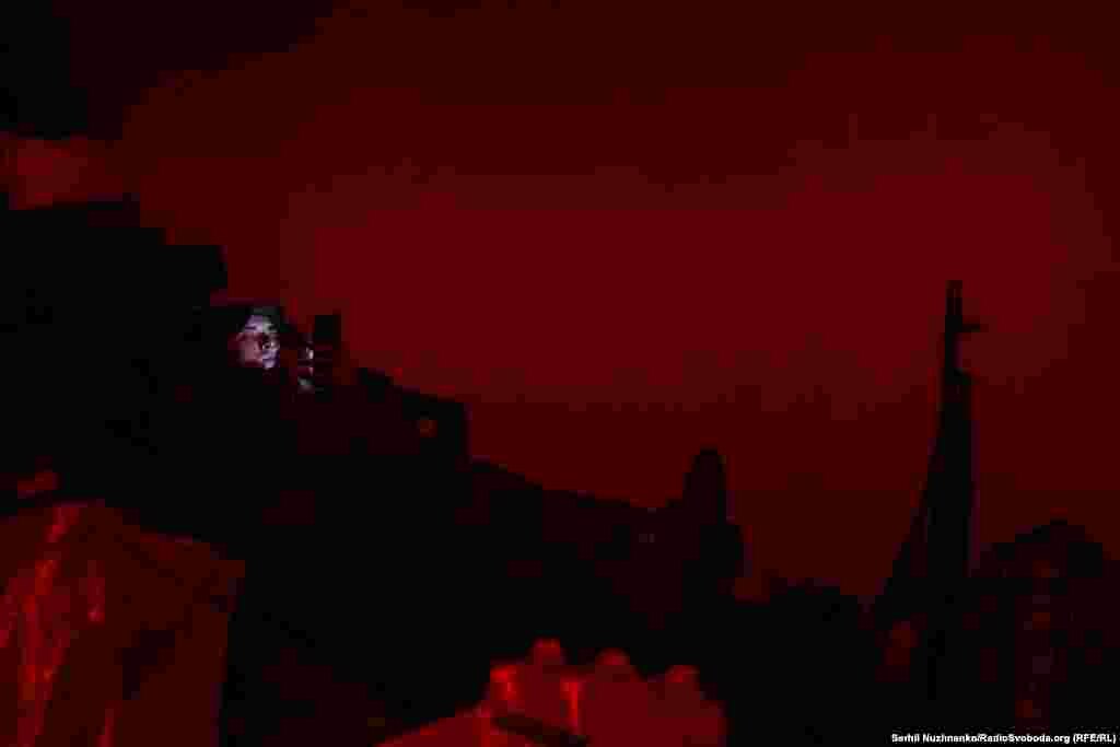 Військовий спілкується з родиною у світлі червоного ліхтарика. Через декілька годин&nbsp;&ndash;&nbsp;він і його підрозділ братиме участь у штурмових&nbsp;&nbsp;діях на північ від Бахмута. Травень 2023 року&nbsp;