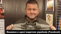 Головнокомандувач Збройних сил України Валерій Залужний тримає відтворену сорочку Степана Бандери. Сорочку за світлиною відтворив проєкт «Вишивка в одязі видатних українців»