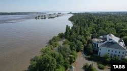 Херсон өлкәсенең Новая Каховка шәһәреннән биш чакрым ераклыкта урнашкан гидроэлектр станциясе буасы өлешчә җимерелгәннән соң төшерелгән фото, якын-тирә торак-пунктларны су баса башлады