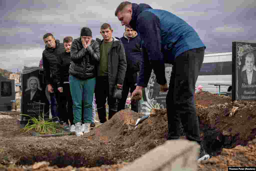 У селі Гроза Куп&rsquo;янського району Харківщини цього тижня ховають тих, кого вдалося опізнати після російського ракетного удару 5 жовтня. На фото: рідні прощаються з 52-річною Тетяною Харбакою, Гроза, Куп&#39;янський район, Харківська область, 9 жовтня 2023 року