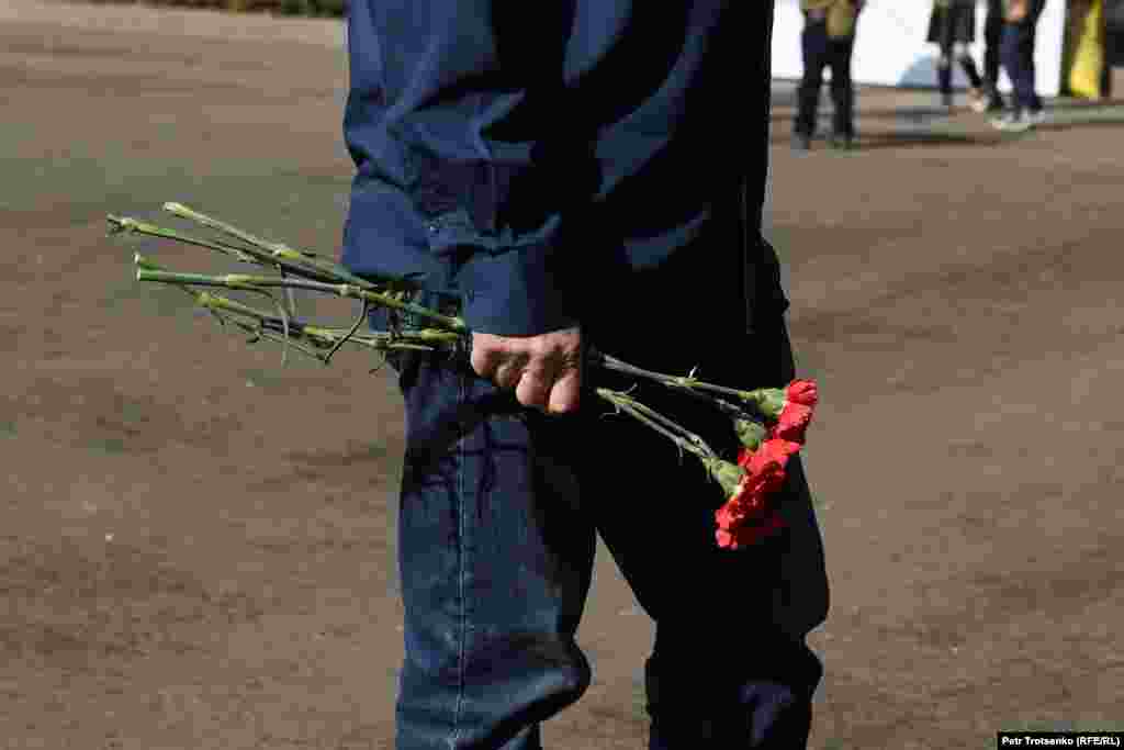 Мужчина держит в руках букет гвоздик