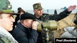 Президент України Леонід Кучма на острові Тузла дивиться на російську дамбу, спорудження якої здійснювали від Краснодарського краю Росії, 23 жовтня 2003 року