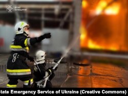 Firefighters extinguish a fire caused by falling missile debris during a Russian attack in the Kyiv region on June 12.