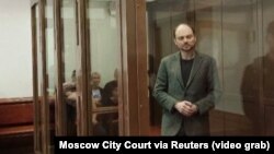 Russian opposition figure Vladimir Kara-Murza stands inside an enclosure for defendants during a court hearing in Moscow on April 17.