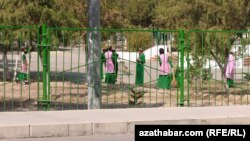 Aşgabatda orta mekdepleriň biriniň howlusynda arassaçylyk işlerini berjaý edýän okuwçy gyzlar (Arhiw suraty)