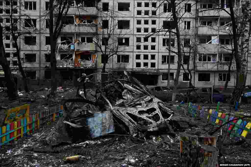 Destroyed cars lie near a children&#39;s playground.