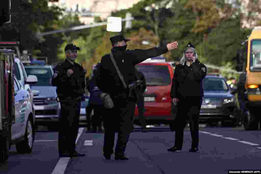 Police officers secure an area outside a damaged nonresidential building on Komsomolsky Prospekt after a reported drone attack. &nbsp;