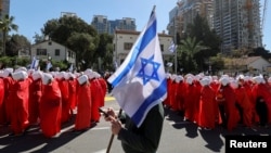 Жінки ходять вулицями, схиливши голови та склавши руки