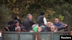 ARMENIA - Refugees from Nagorno-Karabakh region ride in the back of a truck as they arrive in the border village of Kornidzor, September 26, 2023.