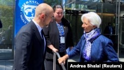 Ukrainian Prime Minister Denys Shmyhal, accompanied by Ukrainian Ambassador to the United States Oksana Markarova (center), talks with European Central Bank President Christine Lagarde near the IMF building in Washington on April 13.