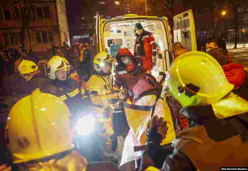 Раненого несут в машину скорой помощи. Обломки попали в несколько жилых домов в Днепровском районе, пострадал по меньшей мере 51 человек, в том числе шестеро детей, сообщил глава военной администрации Киева Сергей Попко. Повреждена система водоснабжения района&nbsp;