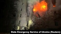 Firefighters work at the site of an apartment building damaged by a Russian air strike in the town of Kupyansk on March 12.
