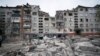 A man looks up at a residential building damaged by a Russian military strike in Slovyansk, Donetsk region, on April 14.