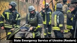 Рятувальники несуть пораненого колегу на місці російського ракетного удару під час атаки Росії на Україну, Одеса, Україна, 15 березня 2024 року (фото архівне)