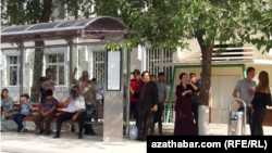Türkmenistanyň awtobus duralgalarynyň birinde transport serişdesine garaşýan ýolagçylar (Illýustrasiýa suraty)