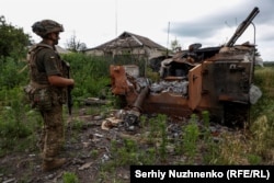 Украинский военный рядом с уничтоженной российской техникой в освобожденном селе Благодатное, Запорожская область, 17 июня 2023 года