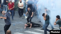 Armenia - A protester is injured by a stun grenade fired by riot police, June 12, 2024.