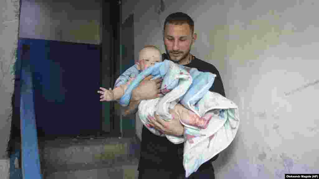 A man carries an injured baby following the missile strike. Reuters reported that the youngest injured was a 3-month-old child. The child&#39;s condition was not immediately known.