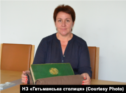 Генеральна директорка Національного заповідника «Гетьманська столиця» Наталія Реброва з «Діаріушем» Пилипа Орлика, який зберігається в Архіві Міністерства Європи та закордонних справ Франції. Фото 2017 року. «Діаріуш» мали привезти на виставку до Батурина, але завадила війна