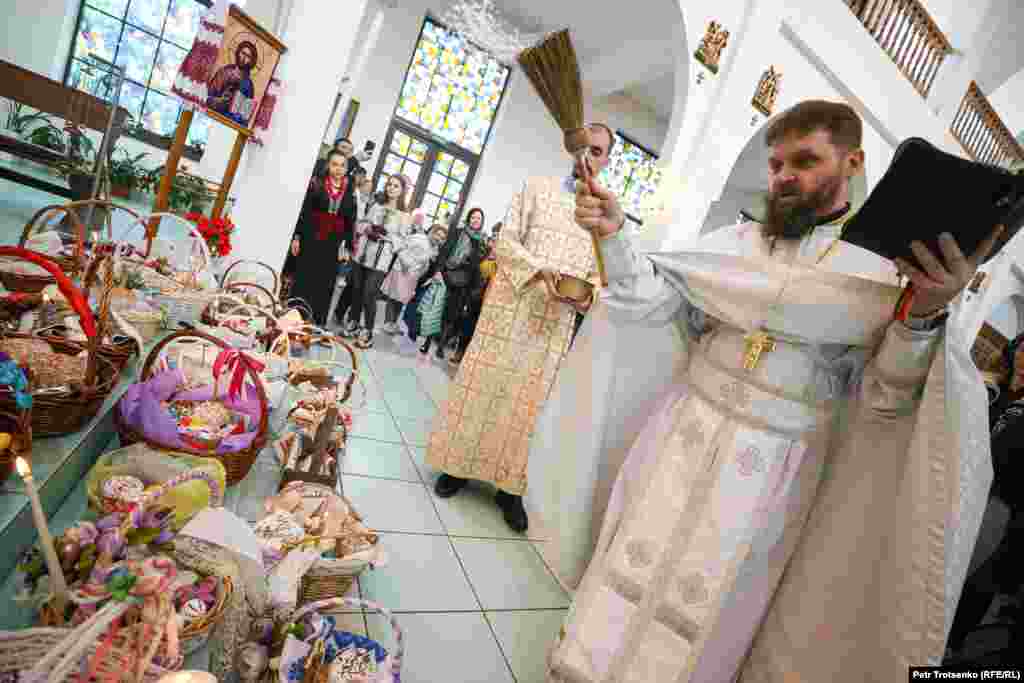 Олег Галушка освещает куличи и яйца, которые прихожане принесли на пасхальную службу