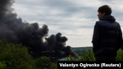 Підліток дивиться на дим, який піднімається після російського ракетного удару в Харкові, 17 травня 2024 року