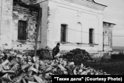 A local resident helps Father Mikhail prepare firewood for the winter near the church.