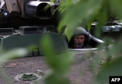 Український морський піхотинець 37-ї бригади дивиться крізь люк бойової броньованої машини AMX-10 RC французького виробництва на позиції в Донецькій області, 10 липня 2023 року