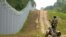 A Latvian border guard patrols along the fence at the border with Belarus near Robeznieki. 