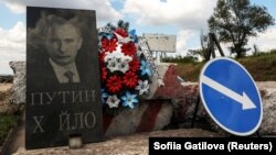 Імітація надгробної плити із зображенням президента Росії Володимира Путіна на блокпості в Донецькій області, 10 липня 2023 року